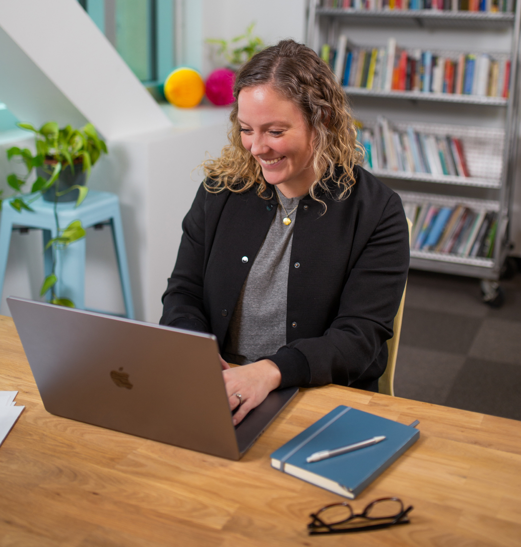 Sam sitting at her computer, researching software